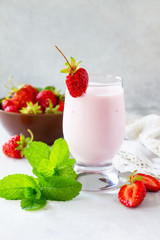 Fresh strawberry smoothie and fresh strawberries on a gray stone or slate background. Vegan dish. Proper nutrition. Healthy lifestyle. Copy space.