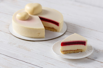 Trendy mousse cake. Slice of cake on a plate Wooden background.