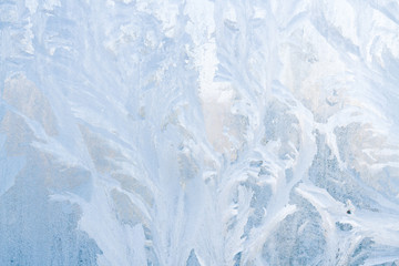 Winter frosty patterns on the frozen ice window