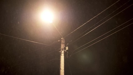 Lamppost lighting up falling snow in the night, seen from under the lamp - Powered by Adobe