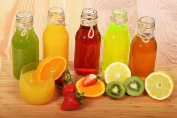 a glass of freshly squeezed orange juice with colorful fruit juices