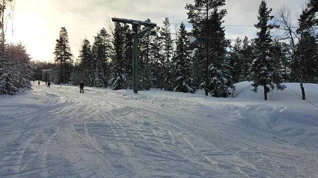 People taking the ski lift at golden hour