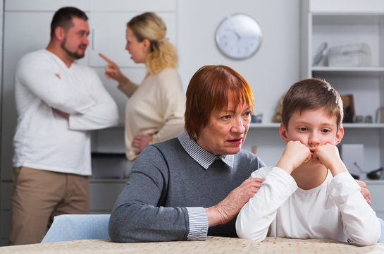 Woman calming boy during parents quarrel