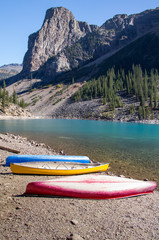 Fototapeta na wymiar Canoes Waiting Alongside Mountain Lake