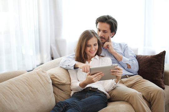 Cheerful couple using tablet