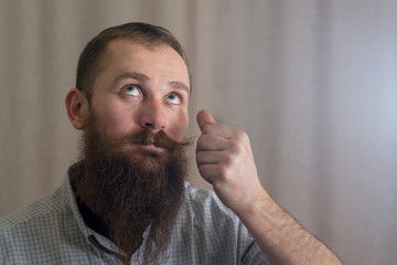 A portrait of a man with a long beard that twists his mustache