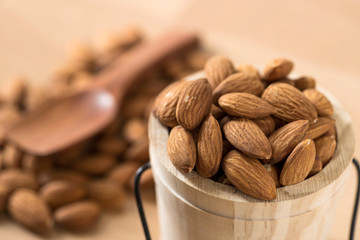 raw natural whole almonds in wood bucket