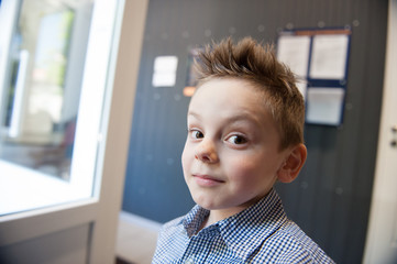 portrait of funny cute little kid with tousled hair indoors