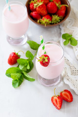 Fresh strawberry smoothie and fresh strawberries on a gray stone or slate background. Vegan dish. Proper nutrition. Healthy lifestyle.