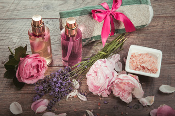 Fototapeta na wymiar Pink English rose, lavender, organic salt and oil, spa wooden background. Rustic style.