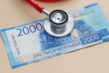 Rubles and stethoscope on a beige background