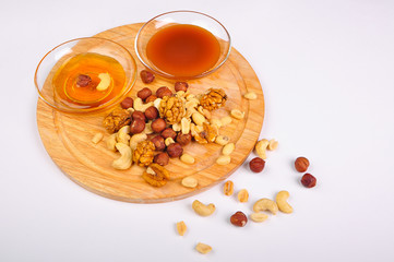 honey with a mix of nuts on a wooden Board