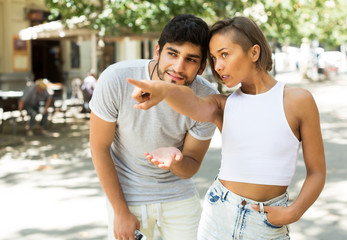 couple talking and pointing finger