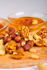 honey with a mix of nuts on a wooden Board