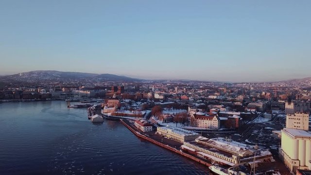 Aerial rising shot towards City Hall and Akershus in Oslo, Norway at sunset