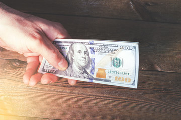 Hands transferring money on wooden background