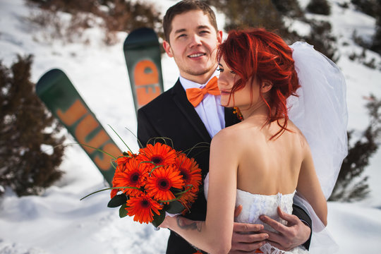 Wedding snowboarders couple just married at mountain winter