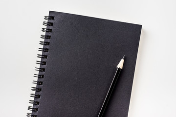 Business concept - Top view collection of black spiral notebook and black pencil isolated on background for mockup