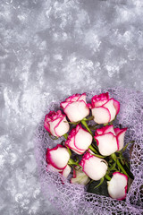 Fototapeta na wymiar Red white rose flower bouquet on stone table.