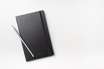 Business concept - Top view collection of black hardcover notebook and silver pencil isolated on background for mockup