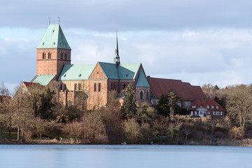 Fototapeta na wymiar Cathedral or Dom of Ratzeburg seen from the Domsee lake in winter, an historic brick romanesque building in northern Germany, copy space