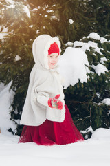 Little girl having fun in the winter forest