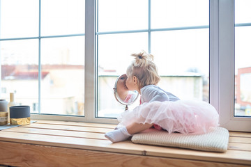 Happy toddler girl looking at herself in the mirror in her house