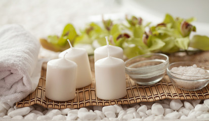 Spa still life with aromatic candles, orchid flower and towel.