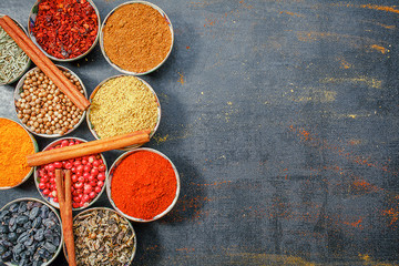 Fototapeta premium Spices and herbs. Variety of spices and mediterranean herbs on black stone