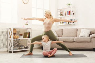 Happy mother and daughter having yoga training at home