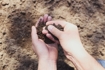 Agrarian with soil in his hands, quality control concept