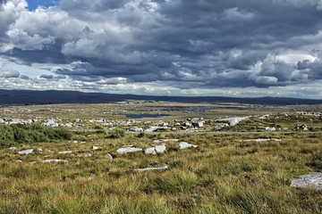 A rocky landscape with a lot of dark clouds.