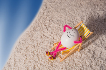 Fototapeta na wymiar Egg lying on a deck chair near the sea