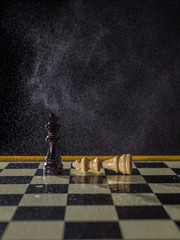 Chess figures on a dark background in the rain. Lose and win Concept. Selective focus