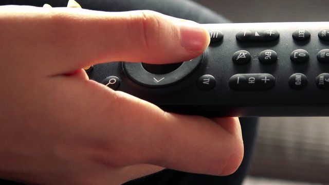 A woman uses a remote control - closeup