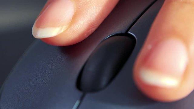 A woman uses a computer mouse - closeup from the front