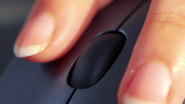 A woman uses a computer mouse - closeup from the front