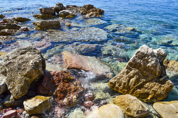 Fototapeta na wymiar The sea view. Beautiful view from the mountain to the calm Adriatic sea. Blue clear water and large stones.