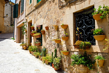 Fototapeta na wymiar Beautiful street in Valldemossa with traditional flower decoration, famous old mediterranean village of Majorca. Balearic island Mallorca, Spain