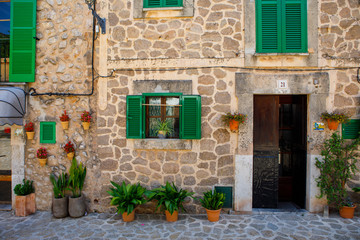 Fototapeta na wymiar Beautiful street in Valldemossa with traditional flower decoration, famous old mediterranean village of Majorca. Balearic island Mallorca, Spain