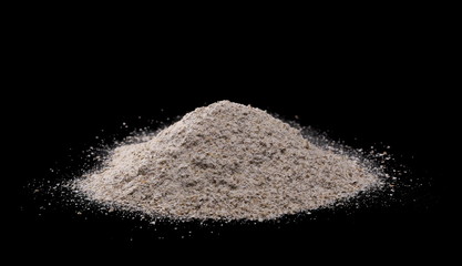 Integral rye flour pile isolated on black background