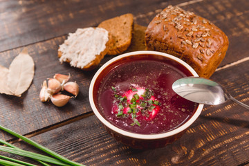 soup with onions and slices of bread on a dark wooden background