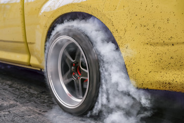 Drag racing car burns rubber off its tires in preparation for the race