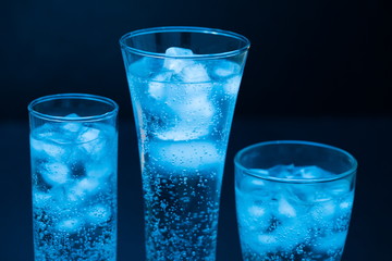 Drink. Water glass and ice, dark background