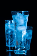Drink. Water glass and ice, dark background