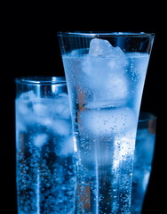 Drink. Water glass and ice, dark background
