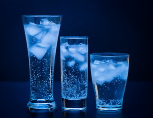 Drink. Water glass and ice, dark background