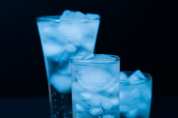 Drink. Water glass and ice, dark background