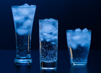 Drink. Water glass and ice, dark background