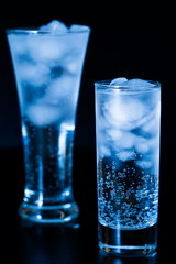 Drink. Water glass and ice, dark background